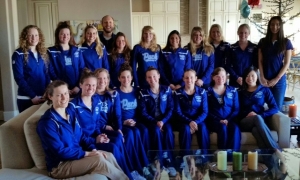 Group photo of team in blue uniforms indoors