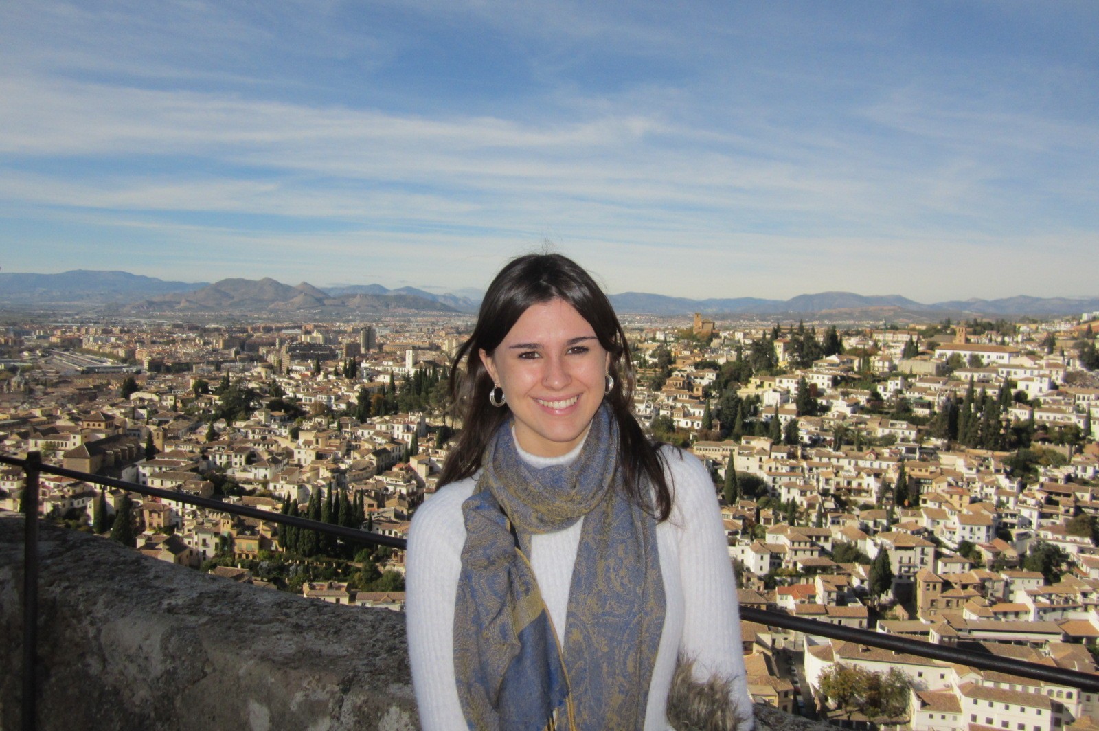 Smiling woman with cityscape and mountains behind
